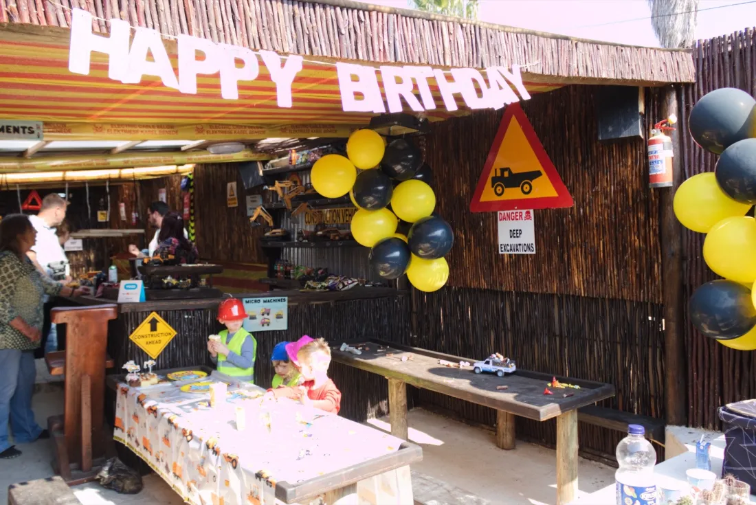 Themed birthday party setup with a Happy Birthday banner and construction balloons