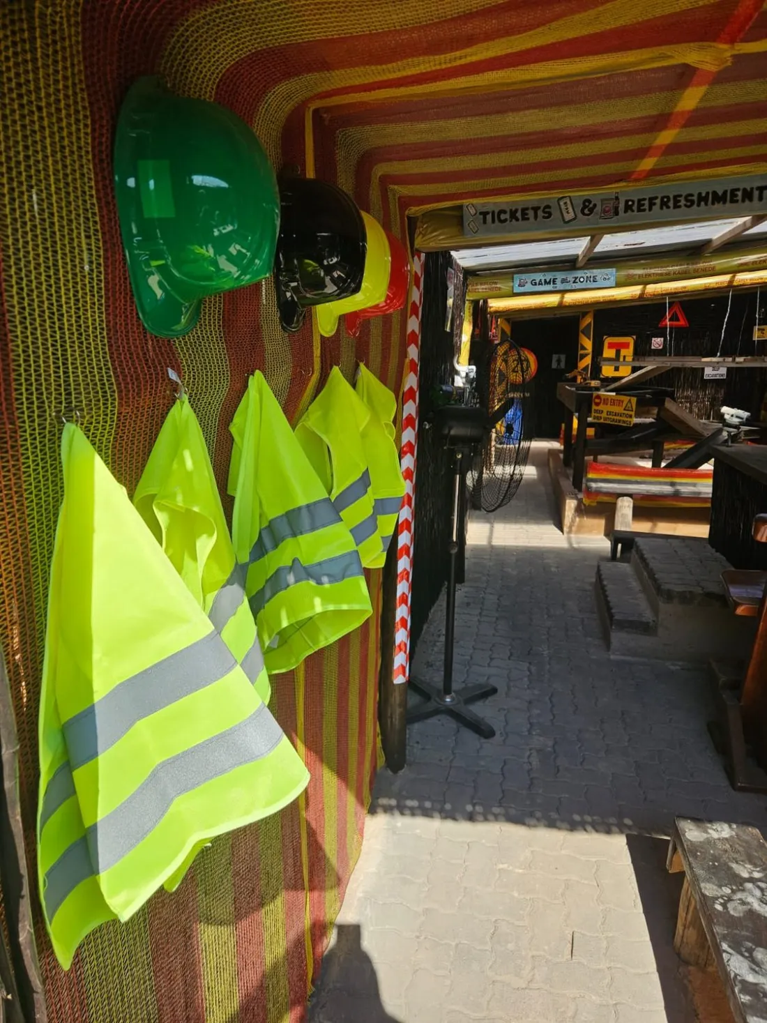 Hi-vis vests and hard hats hanging at the entrance to Backyard Diggers