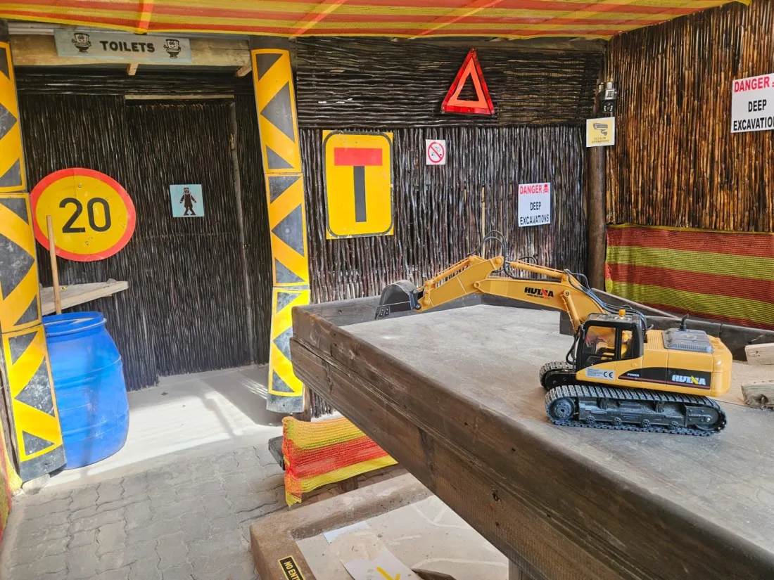 Construction theming with road signs and a digger on a raised platform