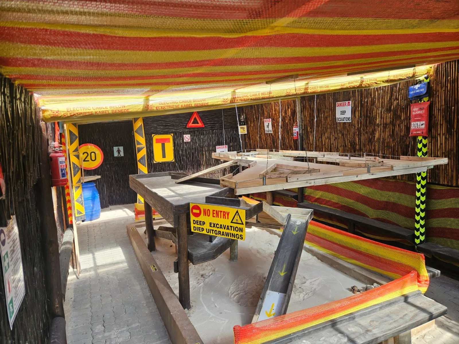 Wide view of the multi-level dig course under the striped shade netting